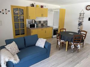 ein Wohnzimmer mit einem blauen Sofa und einem Tisch in der Unterkunft Les Hortensias de Marie in Laviéville