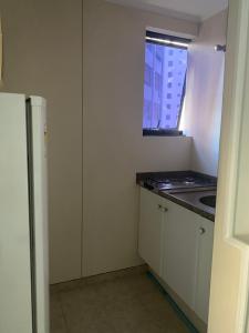 una pequeña cocina con fregadero y ventana en Oscar Freire Jardins SP, en São Paulo