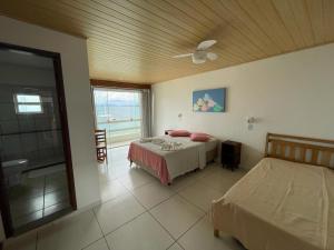 1 dormitorio con 2 camas y ventilador de techo en Pousada do Preto, en Praia do Bananal