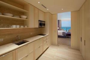 a kitchen with a sink and a room with a bed at The St Regis Bal Harbour Resort in Miami Beach