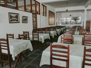 una fila de mesas y sillas en un restaurante en Pousada do Preto, en Praia do Bananal