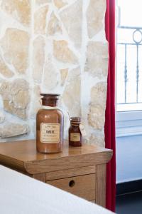 two bottles of honey sitting on a wooden table at Hotel De Belgique à Menton in Menton