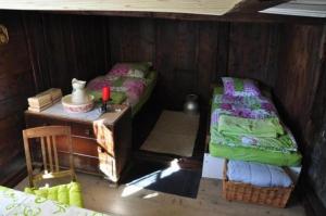 Habitación pequeña con 2 camas y mesa. en Zimmer in uriger rustikalen Alphütte auf bewirtschafteter Alp hoch in den Bergen, inkl VP en Leukerbad