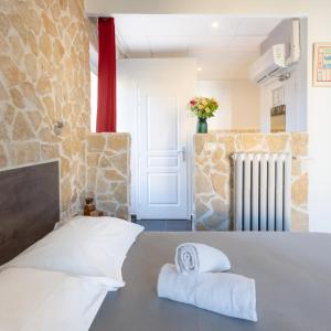 a hotel room with a bed with towels on it at Hotel De Belgique à Menton in Menton