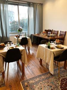 una sala da pranzo con tavoli, sedie e una finestra di SalutBB Chambre d'hote a Carcassonne