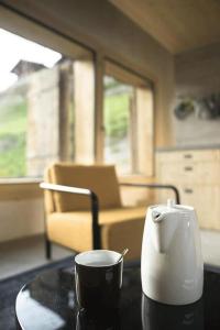 filiżankę kawy siedzącą na stole z kubkiem w obiekcie Mayen à Jean w mieście Haudères