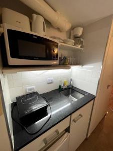 a kitchen with a sink and a microwave at escapada porteña in Buenos Aires