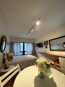 a bedroom with a bed and a table with flowers on it at escapada porteña in Buenos Aires