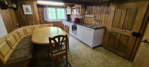 a kitchen with a wooden table and a table and chairs at Ferienhaus Seuzach in Nesslau