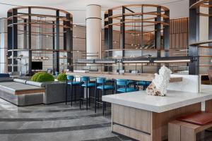 a lobby with a bar with blue stools at Sheraton Zhaoqing Dinghu in Zhaoqing