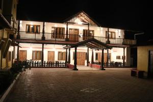 a large building with a lit up courtyard at night at Taniva Dani by CoffeeBeanVilla in Sakleshpur