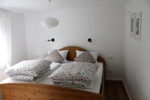 een slaapkamer met een houten bed met kussens erop bij Appartement Gensungen in Felsberg