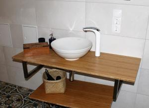 Felsberg的住宿－Appartement Gensungen，浴室水槽,木桌上放着碗