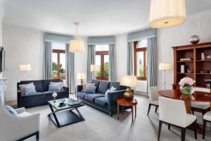 a living room with a blue couch and a table at Hotel Bristol, A Luxury Collection Hotel, Warsaw in Warsaw