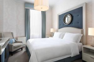 a bedroom with a large white bed and a chair at Hotel Bristol, A Luxury Collection Hotel, Warsaw in Warsaw