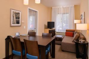 a living room with a table and a couch at TownePlace Suites Wilmington Wrightsville Beach in Wilmington