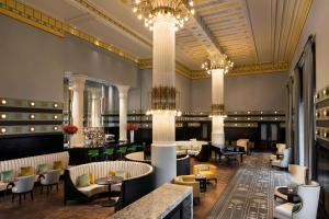 a restaurant with tables and chairs and chandeliers at Hotel Bristol, A Luxury Collection Hotel, Warsaw in Warsaw