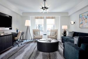 a living room with a blue couch and a tv at JW Marriott Essex House New York in New York