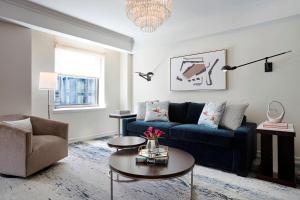 a living room with a blue couch and a table at JW Marriott Essex House New York in New York
