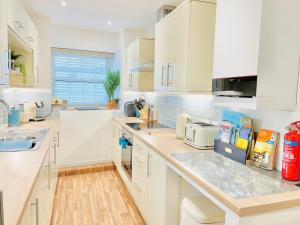 a kitchen with white cabinets and a counter top at Lundy Lookout 5 minutes drive to beach Hot tub in Westward Ho