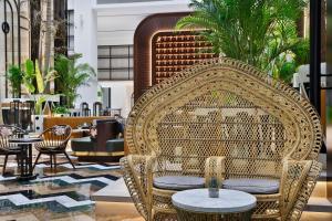 a lobby with wicker chairs and tables in a building at The Westin Dubai Mina Seyahi Beach Resort and Waterpark in Dubai