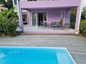 a villa with a swimming pool in front of a house at Villa Maloya in Sainte-Anne