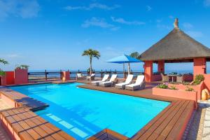 a swimming pool with chairs and a gazebo at The Ritz-Carlton Tenerife, Abama in Guía de Isora