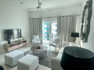 a living room with white furniture and a tv at Sea La Vie! At De Saram Residencies- Mount Lavinia in Watumulla