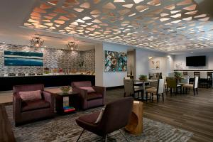 a lobby with a waiting room with chairs and tables at Seattle Marriott Bellevue in Bellevue