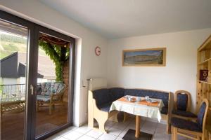 a room with a table and chairs and a balcony at Ferienwohnung „Schwalbennest“ Reil/Mosel in Reil