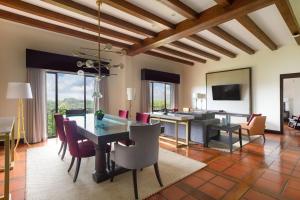 uma sala de jantar com mesa e cadeiras e uma sala de estar em Costa Rica Marriott Hotel Hacienda Belen em San José