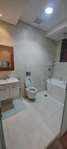 a bathroom with a toilet and a tub and a sink at فيلا ضاحية الرمال in Riyadh