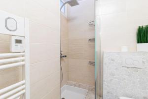 een badkamer met een douche en een glazen deur bij ZenBNB / Sweet Apartment / Studio / Proche Genève in Annemasse