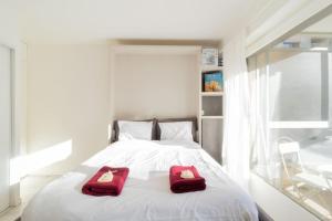 twee rode kussens op een wit bed in een kamer bij ZenBNB / Sweet Apartment / Studio / Proche Genève in Annemasse