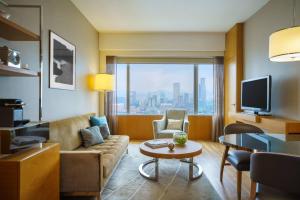un soggiorno con divano e tavolo di Renaissance Hong Kong Harbour View Hotel a Hong Kong