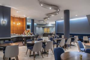 um restaurante com mesas e cadeiras e um bar em Delta Hotels by Marriott Regina em Regina