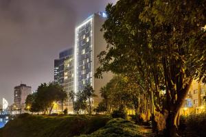 a tall building in a city at night at AC Hotel by Marriott Lima Miraflores in Lima