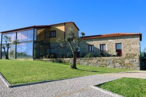 un bâtiment avec un arbre en face dans l'établissement Quinta das Areias - Solar da Pena, à Braga