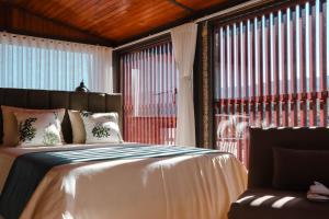 a bedroom with a bed and a large window at Quinta das Areias - Solar da Pena in Braga