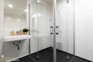 een witte badkamer met een wastafel en een douche bij Pineapple Apartments Dresden Altstadt II - 124 qm - 1x free parking in Dresden