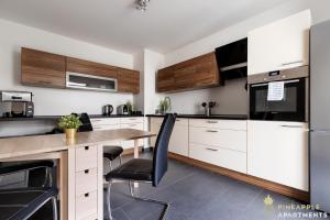 uma cozinha com armários brancos e uma mesa de madeira em Pineapple Apartments Dresden Altstadt II - 124 qm - 1x free parking em Dresden