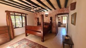 a bedroom with a bed in a room with a ceiling at Charming 2-Bed Cottage in Bodo a fishing village in Funzi
