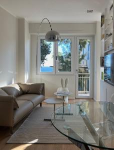 uma sala de estar com um sofá e uma mesa de vidro em Asso di Picche, Luxury suite em Sanremo