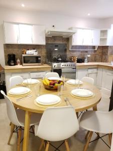 una cucina con tavolo in legno e armadietti bianchi di Casa Isabel a Cuenca