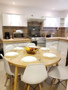 Una cocina con una mesa de madera y gabinetes blancos. en Casa Isabel, en Cuenca