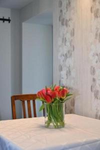 un jarrón de rosas rojas sentado en una mesa en Seeblick - a78060 en Stalden