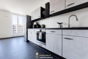 cocina con armarios blancos y fogones en Pineapple Apartments Dresden Altstadt III - 91 qm - 1x free parking en Dresden