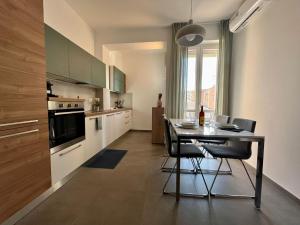 uma cozinha com mesa e cadeiras num quarto em Cozy Apartment San Siro em Milão