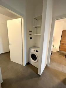 een wasruimte met een wasmachine en een deur bij Cozy Apartment San Siro in Milaan
