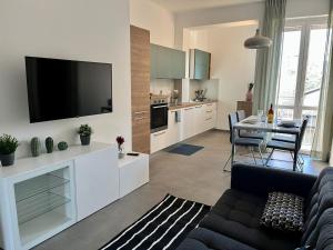 uma sala de estar com um sofá e uma televisão na parede em Cozy Apartment San Siro em Milão